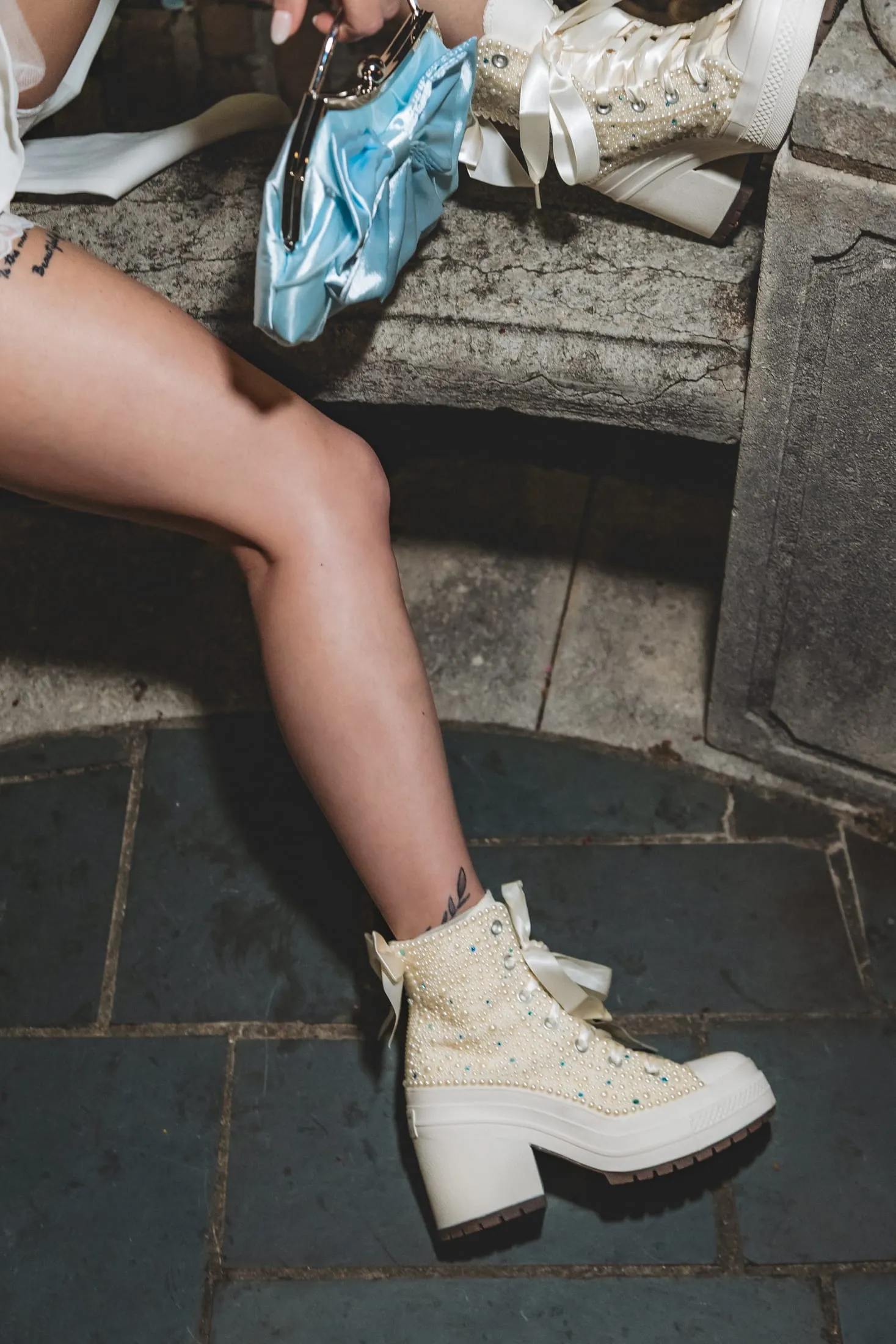 Editorial shot of a bride wearing retro-court bridal sneakers.