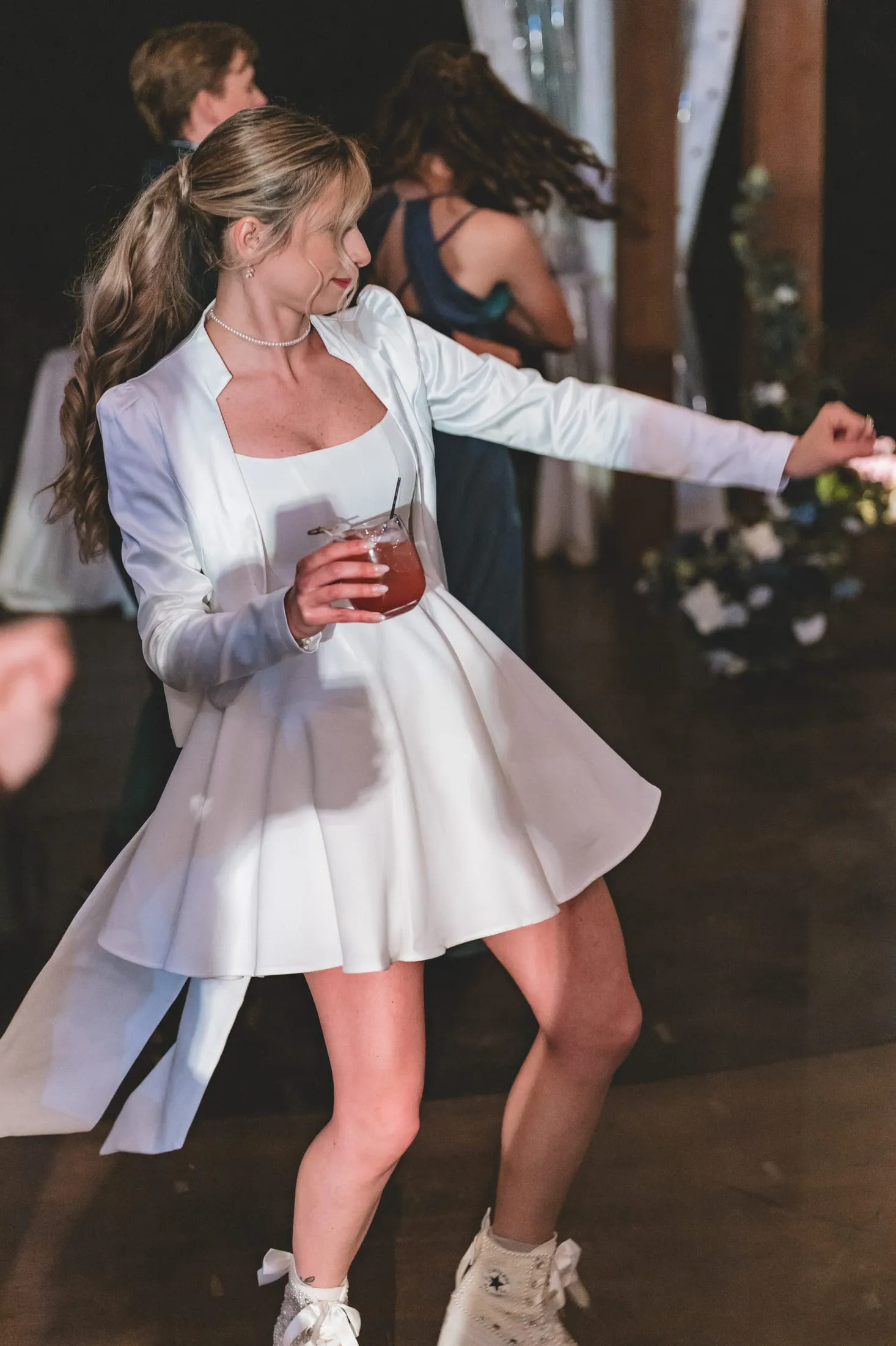Bride dancing at her reception in custom bridal sneakers.