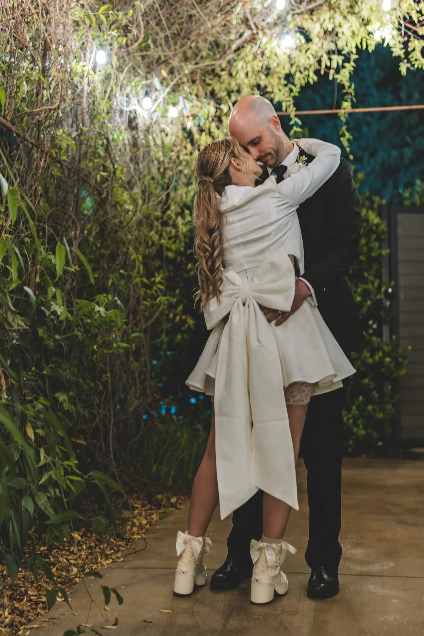 Couple sharing their first dance, the bride in custom bridal sneakers.