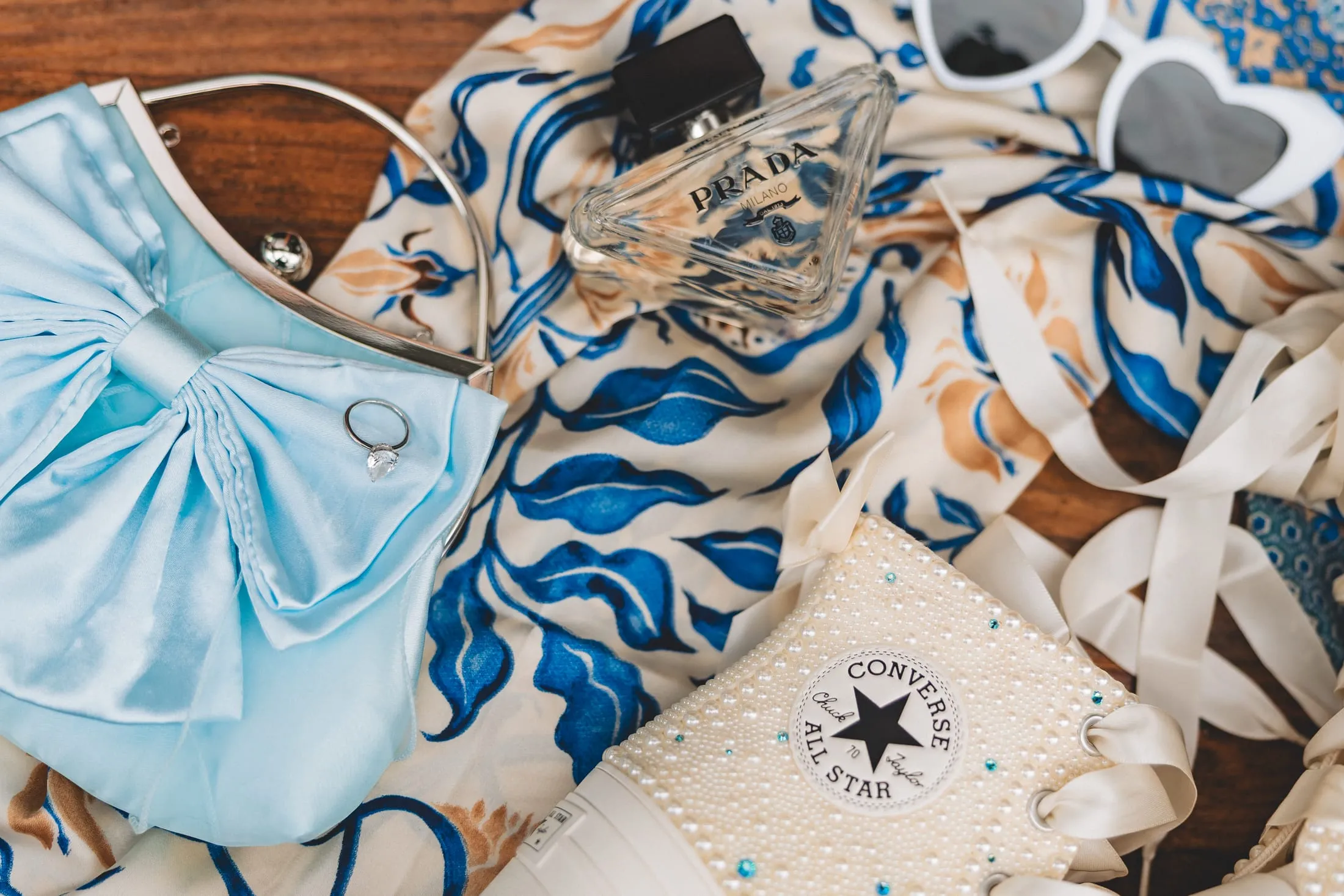 Flat-lay of custom bridal sneakers with blue accents.